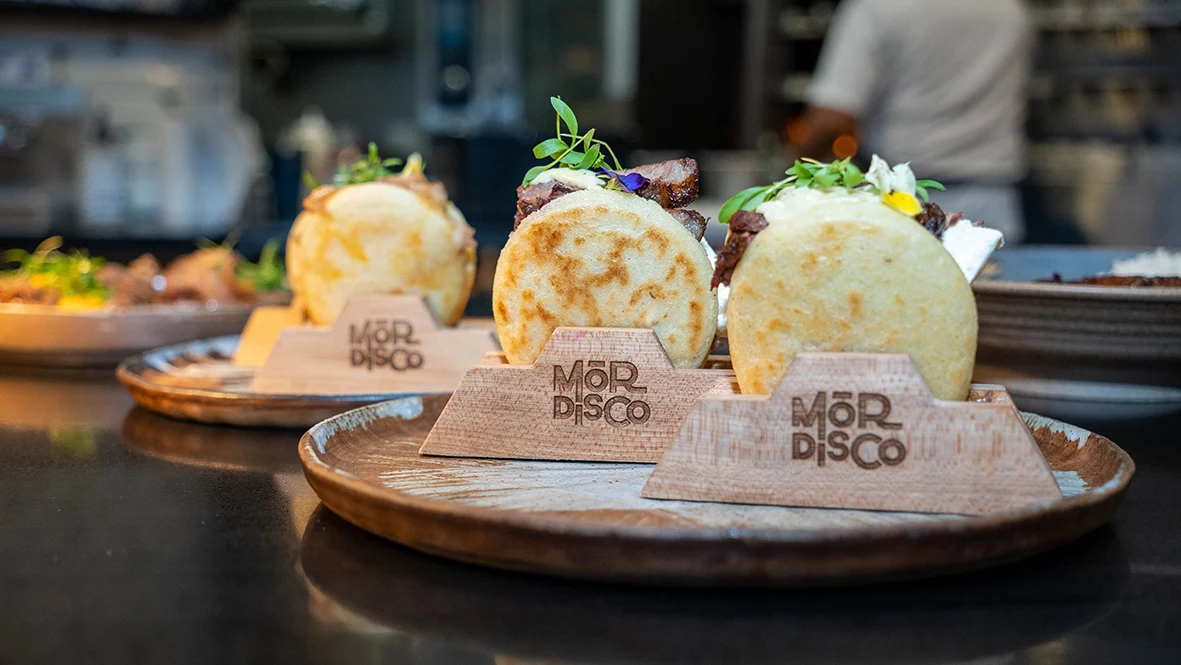 Freshly filled Mordisco arepas on wooden serving boards