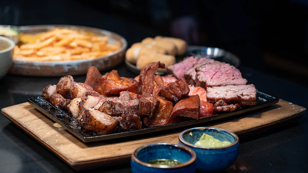 A Mordisco sharing parrilla with grilled meats, sausage, pork belly and house sauces